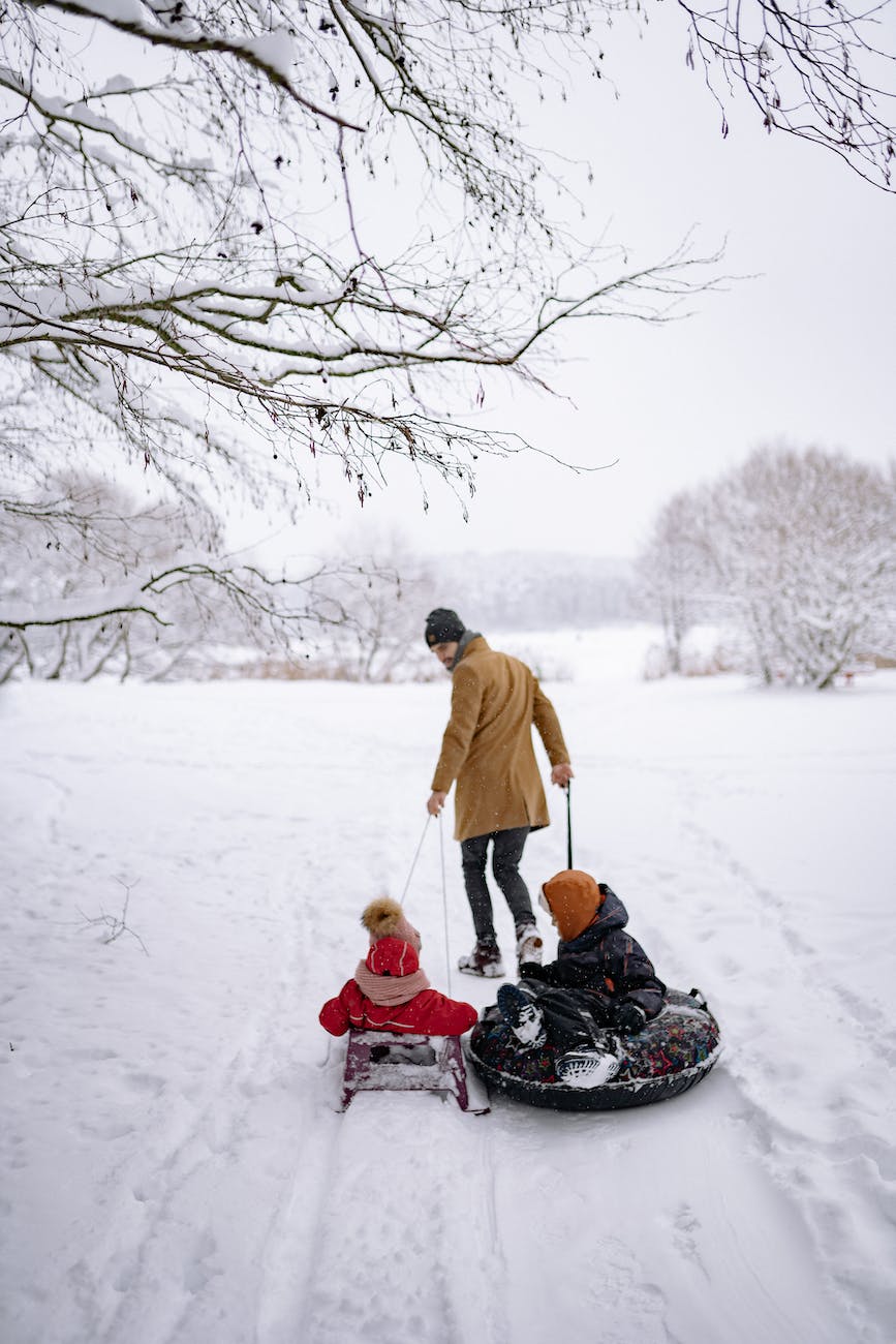 a man pulling a sled and snow tube